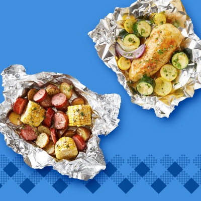 Savory foil packets: one bursting with juicy sausage, sweet corn, and tender potatoes; the other with herb-crusted chicken, caramelized squash, and red onion—served on a vibrant blue backdrop.