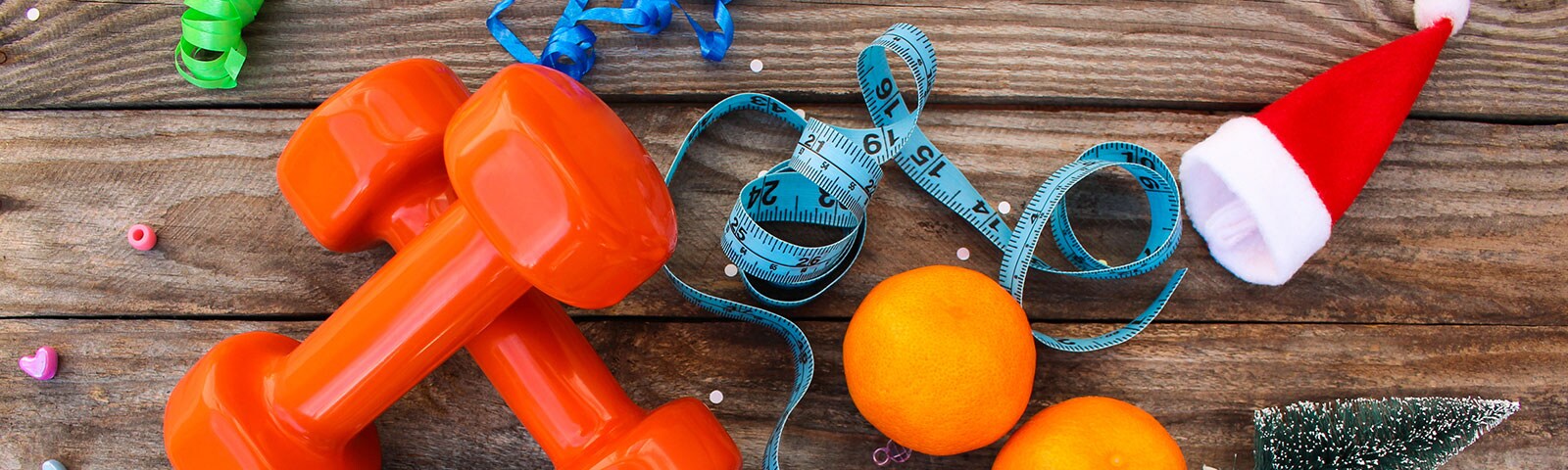 Weights and oranges on a wooden table to stay healthy Weights and oranges on a wooden table to stay healthy