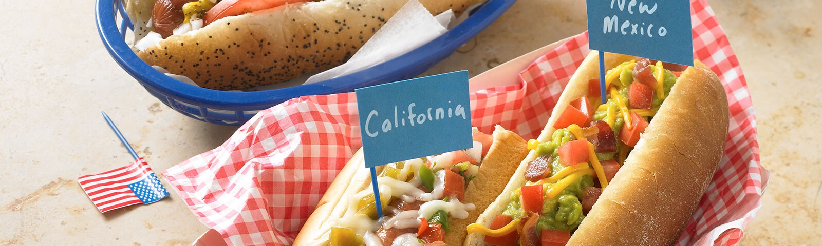 Chicago, New Mexico and California-style hot dogs with pickle relish, tomato slices and shredded cheeses as toppings
