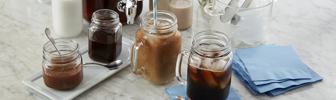 Mason jar cups with iced coffee and ice cubes