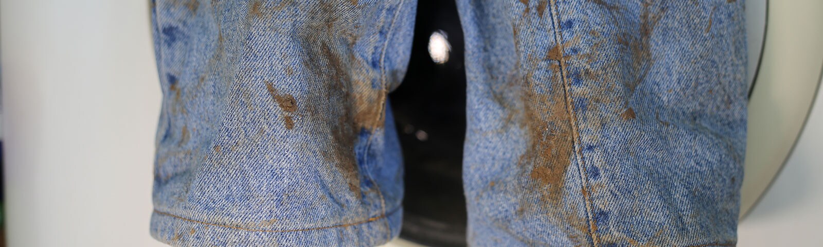 A pair of jeans covered with brown stains