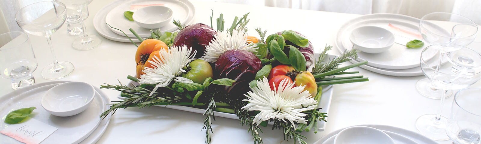 Fruits and veggies on a white platter on a white table Fruits and veggies on a white platter on a white table