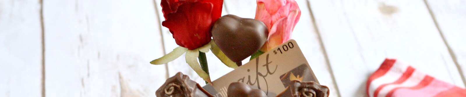 Close up of roses, chocolates and a $100 gift card Close up of roses, chocolates and a $100 gift card