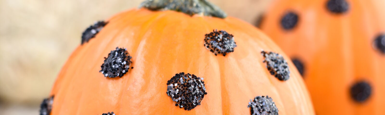 Pumpkins decorated with DIY black glitter polka dots