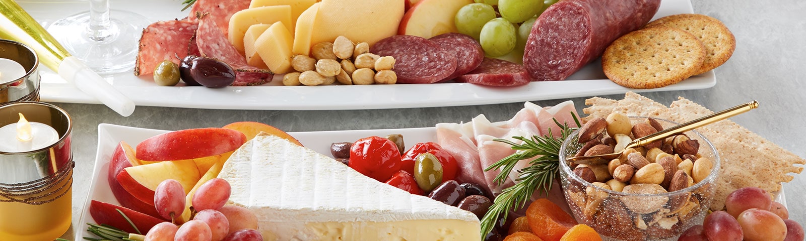 Meat and cheese platters on a table next to a flameless candle Meat and cheese platters on a table next to a flameless candle