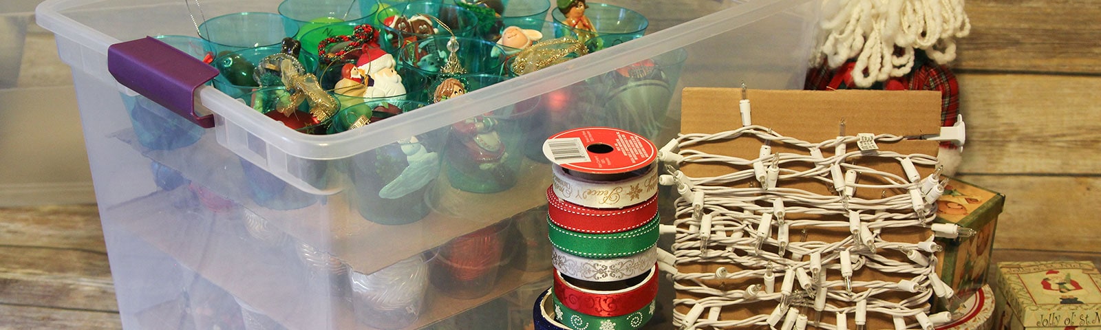 Christmas ornaments, lights and wrapping supplies organized in a plastic storage bin